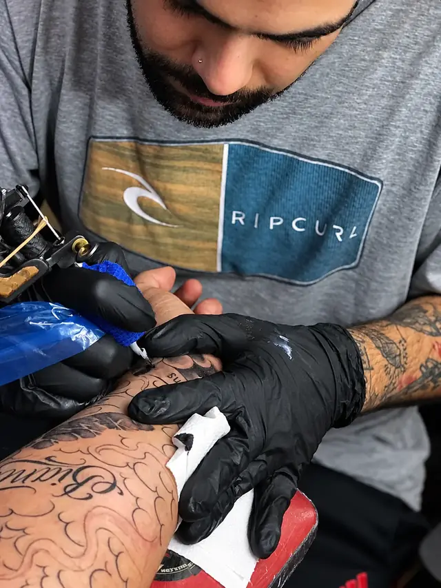 Seba Puratinta tatuando un diseño en una mano